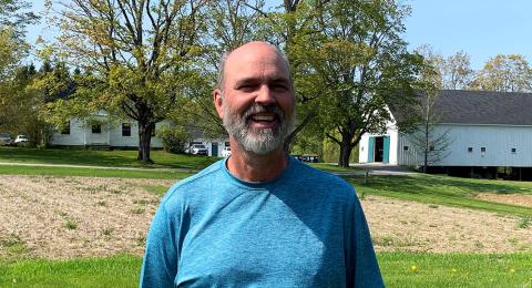A photo of UNH farm manager Evan Ford standing in a field at the Woodman Horticultural Research Farm.
